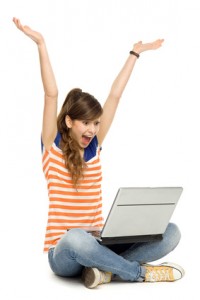 Woman with arms raised using laptop